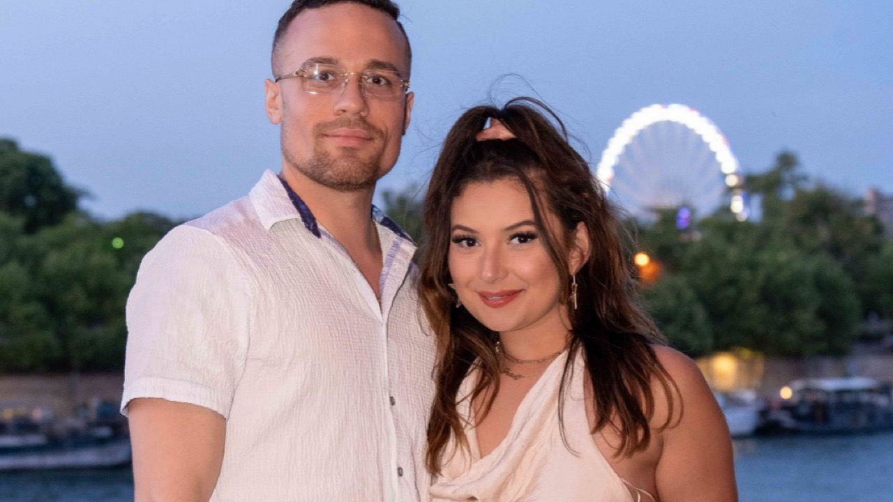 Couple en séance photo au bord de la Seine à Paris en soirée, grande roue illuminée en arrière-plan