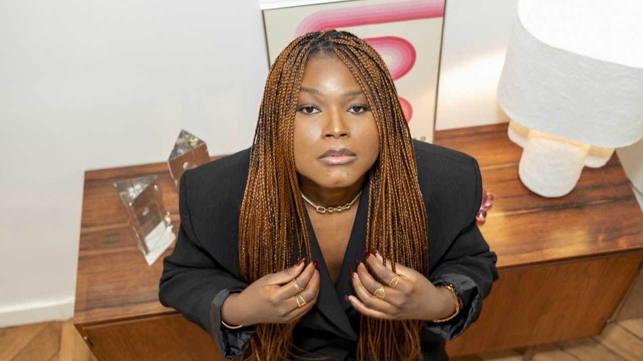 Portrait en lumière naturelle d'une femme aux longues tresses, blazer noir, à Paris